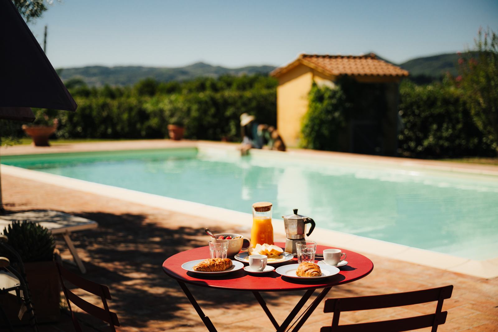 Tavolo della colazione a bordo piscina con vista sulle colline